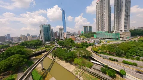 Cinematic FPV drone flight over LRT train tracks with Kuala Lumpur city skyline. Stock Footage 306516244
