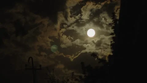 Cinematic full moon shining through dramatic dark clouds at night Stock Footage 335918986