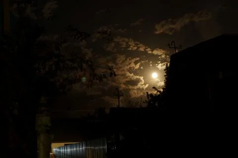 Cinematic full moon shining through dramatic dark clouds at night Foto stock