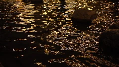 Cinematic golden reflections dancing across dark water at night Stock-Footage 341536208