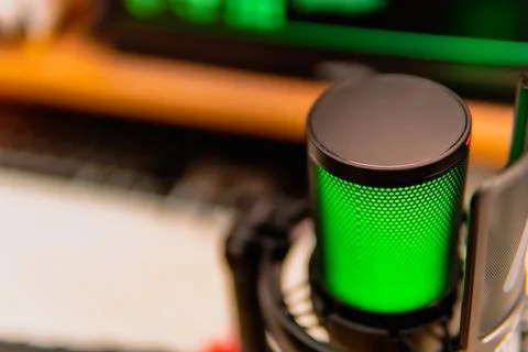 Cinematic hacker workspace with green code screens and microphone setup Stock Photos