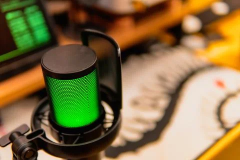 Cinematic hacker workspace with green code screens and microphone setup Stock Photos