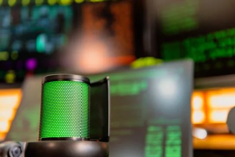 Cinematic hacker workspace with green code screens and microphone setup Stock Photos