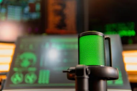 Cinematic hacker workspace with green code screens and microphone setup 스톡 사진