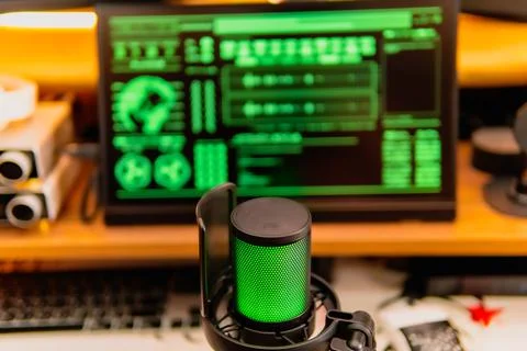 Cinematic hacker workspace with green code screens and microphone setup Stock Photos
