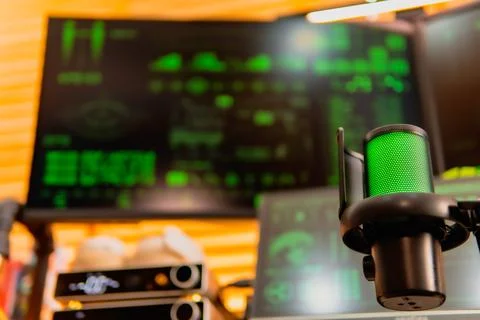 Cinematic hacker workspace with green code screens and microphone setup Stock Photos