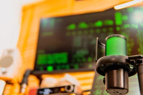 Cinematic hacker workspace with green code screens and microphone setup Foto stock