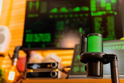 Cinematic hacker workspace with green code screens and microphone setup Foto stock