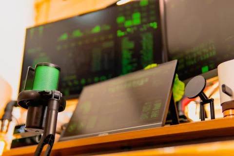 Cinematic hacker workspace with green code screens and microphone setup Stock Photos