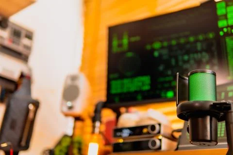 Cinematic hacker workspace with green code screens and microphone setup Stock Photos