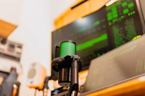 Cinematic hacker workspace with green code screens and microphone setup Stock Photos