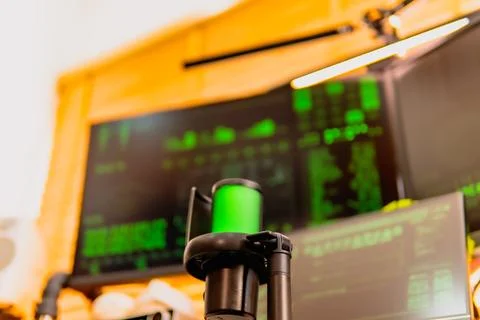 Cinematic hacker workspace with green code screens and microphone setup Stock Photos