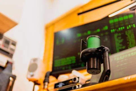 Cinematic hacker workspace with green code screens and microphone setup 스톡 사진