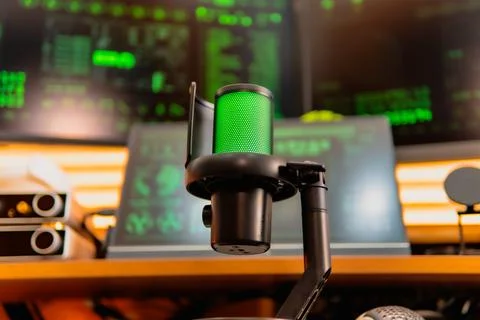 Cinematic hacker workspace with green code screens and microphone setup Stock Photos