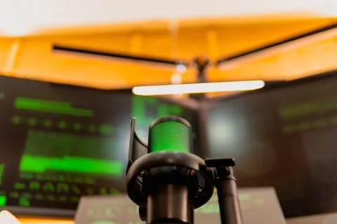 Cinematic hacker workspace with green code screens and microphone setup Stock Photos