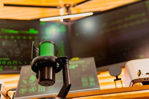 Cinematic hacker workspace with green code screens and microphone setup 写真素材