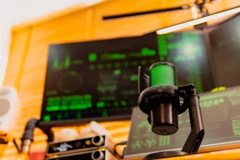 Cinematic hacker workspace with green code screens and microphone setup Stock Photos