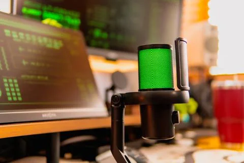 Cinematic hacker workspace with green code screens and microphone setup Stock Photos