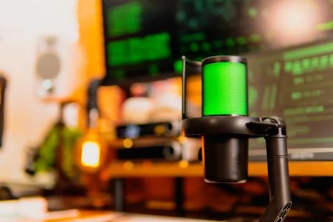 Cinematic hacker workspace with green code screens and microphone setup Stock Photos