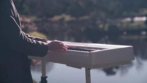 Cinematic Hands Playing White Digital Piano Outdoors Near Water Vídeo Stock 334001103
