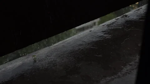 Cinematic heavy rain falling on a concrete surface beneath during a storm 库存影片 340901040