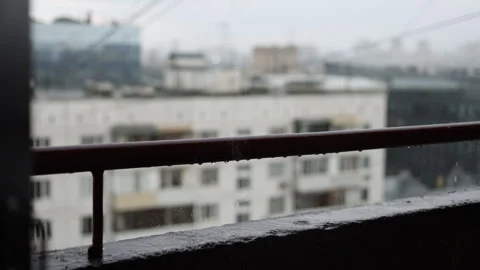 Cinematic heavy rain over a modern city viewed from a balcony 스톡 동영상 340901008