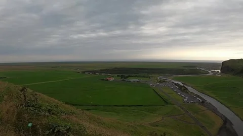 Cinematic high-angle landscape of green plains and river delta in South Iceland Stock Footage 334741903