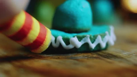 Cinematic ingredient sequence of icing detail around a colorful sombrero cookie Stock Footage 342156120