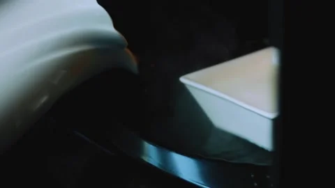 Cinematic ingredient study of carrying the square flan mold toward the oven Stock Footage 342154046