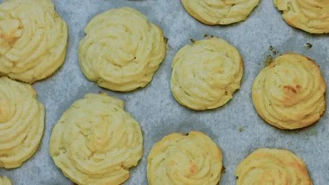 Cinematic kitchen technique: baking duchess potatoes until golden Stock Photos