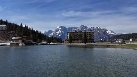 Cinematic Lateral Panning Shot Tracking Lakeside Roads and Jagged Alpine Video stock 341074346