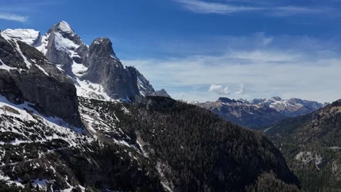 Cinematic Lateral Tracking Flight Over Dense Pine Ridges Facing Snowy Cr Video stock 340000423