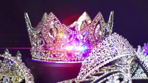 Cinematic lens flares highlight a showcase of royal crowns and tiaras Stock Footage