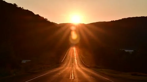 Cinematic look of setting sun over mountain road Stock Footage 255664549
