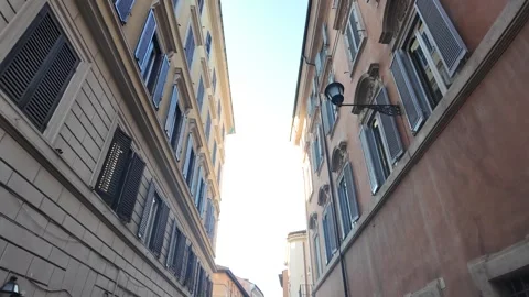Cinematic low angle footage looking up at historic narrow Roman alleyways Stock Footage 342174484
