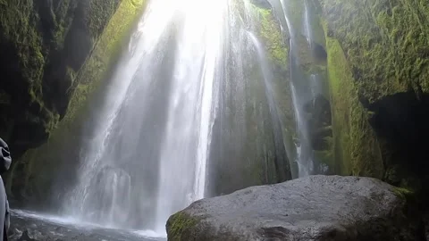 Cinematic low-angle view of hidden waterfall and large rock in canyon, 4K Stock Footage 334808989