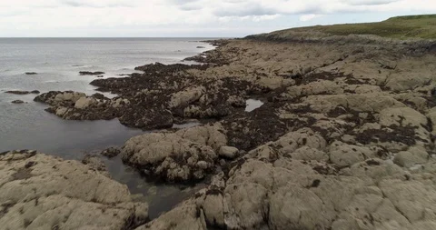 Cinematic low fly over rocks on Wleshe coastline drone aerial 4k Stock Footage 114157041