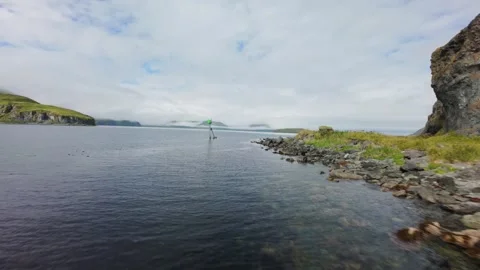Cinematic low FPV drone flight over the coastline Unalaska, Alaska, past a Stock Footage 320097544
