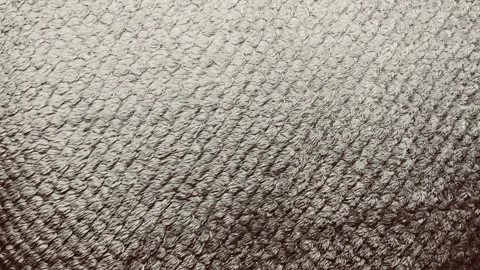 Cinematic macro tracking shot glides over textured organic beige cotton fabric r Stock Footage 337550526