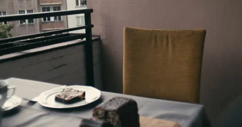 Cinematic medium shot of empty chair at table with coffee and cake 動画素材 345922449