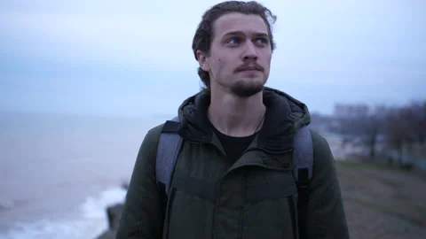 Cinematic moody man walk empty area on the sea coast in autumn wet day Stock Footage 151606991