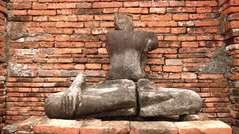 Cinematic motion push back from ancient sitting headless Buddha statue at Wat Stock Footage 312491181