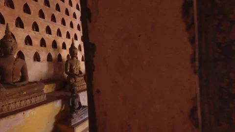 Cinematic motion to the rows of many various old Buddha statues sitting in Stock Footage 285917947