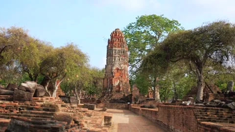 Cinematic motion toward to Weathered Leaning Prang Tower Beside Trees and Ruins 스톡 동영상 312661856