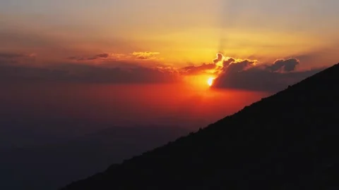 Cinematic mountain sunset sun rays piercing through clouds dramatic orange .. Vídeos de archivo 336206011