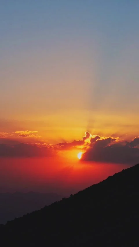 Cinematic mountain sunset sun rays piercing through clouds dramatic orange .. Stock Footage 336229037