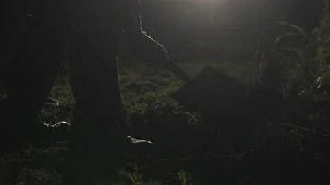 Cinematic Murderer Digging Hole At Night To Dispose Victim's Body Stock Footage 108790911