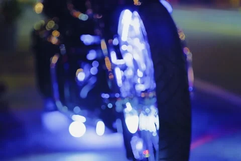 Cinematic Night Close-Up of Custom Chrome Motorcycle Wheel Illuminated by Blue N Stock Footage 321714874