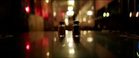 Cinematic Night Restaurant Table With Salt and Pepper Shakers in Soft Bokeh Ligh Stock Footage 321311093