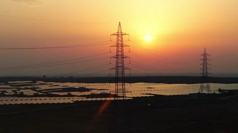 Cinematic Orbit Drone Shot Around High Voltage Transmission Tower and Solar Stock Footage 338066420